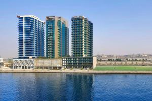 a group of tall buildings next to a body of water at The First Collection Waterfront, Dubai, a Tribute Portfolio Hotel in Dubai