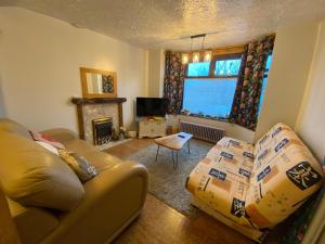 ein Wohnzimmer mit Sofa und Kamin in der Unterkunft Bungalow in Badsey, north of Cotswolds in South Littleton