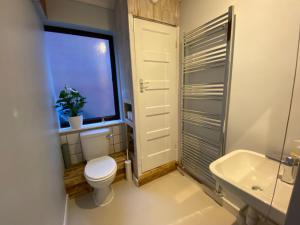 ein Bad mit einem WC, einem Fenster und einem Waschbecken in der Unterkunft Bungalow in Badsey, north of Cotswolds in South Littleton + 21 Fotos