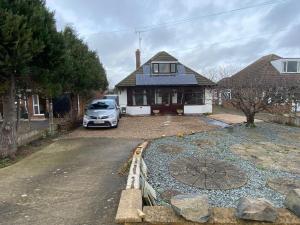 ein vor einem Haus geparktes Auto in der Unterkunft Bungalow in Badsey, north of Cotswolds in South Littleton