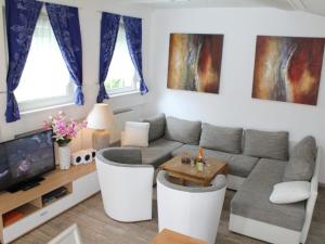 a living room with a couch and a tv at Apartment Vulkaneifel by Interhome in Daun