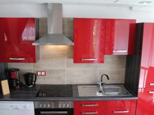 a kitchen with red cabinets and a sink at Apartment Vulkaneifel by Interhome in Daun +32 photos