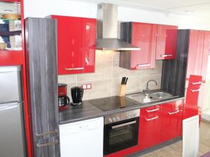 a kitchen with red cabinets and a sink at Apartment Vulkaneifel by Interhome in Daun