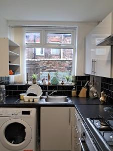 a kitchen with a sink and a washing machine at 16 Skipton Road in Liverpool