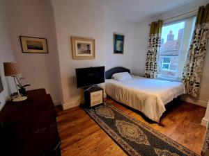 a bedroom with a bed and a tv and a window at 16 Skipton Road in Liverpool