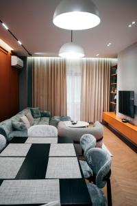 een woonkamer met een bank, een tafel en stoelen bij Amarus Apartments in Gjirokastër