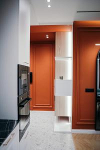 een keuken met een oranje deur en een magnetron bij Amarus Apartments in Gjirokastër