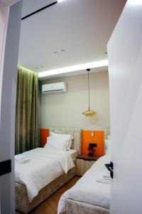 een slaapkamer met 2 bedden en een bank bij Amarus Apartments in Gjirokastër