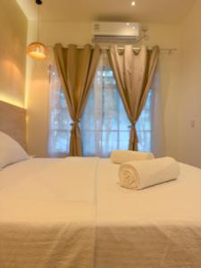 a bed with two towels on it with a window at Cocomero Inn in Fulidhoo