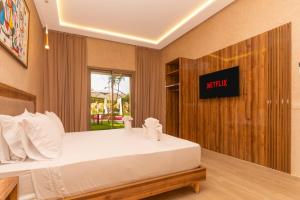 een slaapkamer met een bed met een bord aan de muur bij Villa hasard in Had Abdallah Rhiat