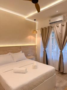 a bedroom with a white bed and a window at Cocomero Inn in Fulidhoo