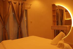 a bedroom with a bed with a mirror and a shower at Cocomero Inn in Fulidhoo