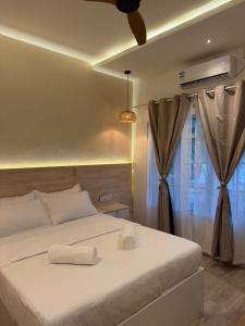 a bedroom with a white bed and a window at Cocomero Inn in Fulidhoo