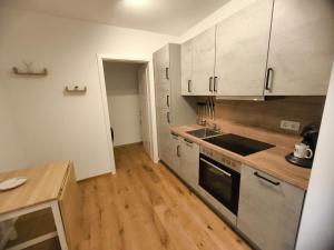 a kitchen with white cabinets and a wooden floor at SeeZeitApartments Whg 27 in Lembruch