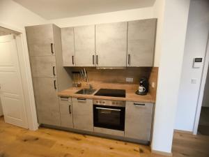a kitchen with white cabinets and a stove top oven at SeeZeitApartments Whg 27 in Lembruch