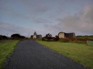 een grindweg die naar twee huizen in een veld leidt bij Stag's View in Ballina