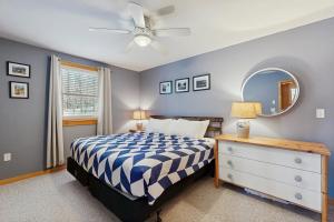 una camera da letto con un letto, un comò e uno specchio di Eidelweiss Retreat a Madison
