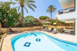 ein Swimmingpool in einem Garten mit Palmen in der Unterkunft Gran Sol Family 5 in Cala Ferrera