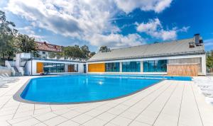 a swimming pool in front of a building at Feniks Apartamenty - Holiday Home in Kołobrzeg