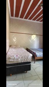 een slaapkamer met twee bedden in een kamer bij POUSADA Cantinho e Sossego casa 1 in Vespasiano