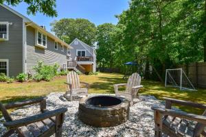 a backyard with two chairs and a fire pit at Minutes to Private Association in Eastham