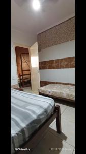 een kamer met twee bedden en een gang met een deur bij POUSADA Cantinho e Sossego casa 1 in Vespasiano