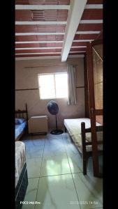 een kleine kamer met twee bedden en een raam bij POUSADA Cantinho e Sossego casa 1 in Vespasiano