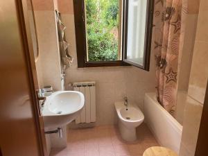 a bathroom with a sink and a toilet and a window at Scavi & Sogni Romani in Ostia Antica +23 photos
