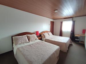 a hotel room with two beds and a window at Apartamento completo cerca del Aeropuerto y Parque Viva 5 personas in Guácima