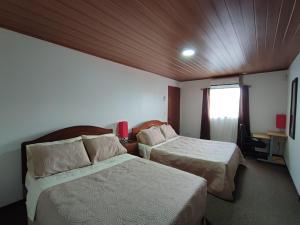 a hotel room with two beds and a window at Apartamento completo cerca del Aeropuerto y Parque Viva 5 personas in Guácima +21 photos