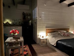een slaapkamer met een bed en een klein tafeltje met een tafeltje sidx sidx bij Mika Tiny House in Daia