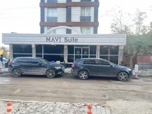 two cars parked in a parking lot in front of amax shuttle at Maraş Blue Life Suit in Kahramanmaraş