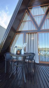 un tavolo e sedie su una terrazza in legno con finestra di Cabana Flamboyant 1 a Piratuba