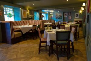 a dining room with tables and chairs in a restaurant at Pen y Bryn in Conwy