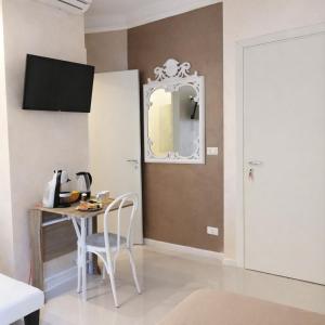 ein Esszimmer mit Tisch und Spiegel in der Unterkunft Blu Marina Alassio in Alassio