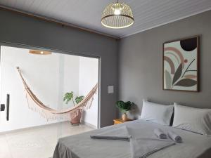 een slaapkamer met een bed en een hangmat bij Pousada jks in Porto Seguro