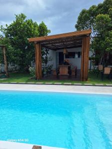 een pergola en een zwembad in de tuin bij Pousada jks in Porto Seguro