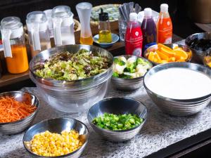 a counter topped with bowls of different types of food at APA Hotel Asakusa Kuramae in Tokyo