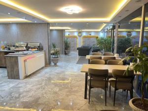 a restaurant with tables and chairs in a lobby at Maraş Blue Life Suit in Kahramanmaraş