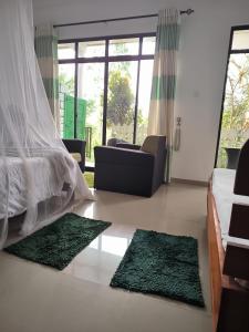 een slaapkamer met een bed en twee groene vloerkleden bij Slon White Elephant Ella in Ella