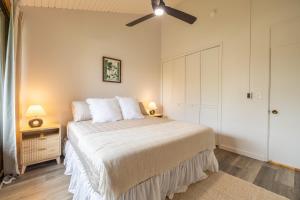 een slaapkamer met een bed en een plafondventilator bij Kuilima West 101 condo in Kawela Bay