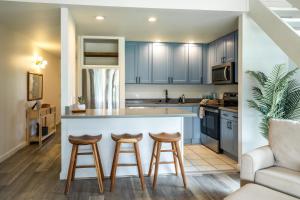 een keuken met blauwe kasten en 2 barkrukken bij Kuilima West 101 condo in Kawela Bay +8 foto's