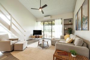 een woonkamer met een bank en een tv bij Kuilima West 101 condo in Kawela Bay