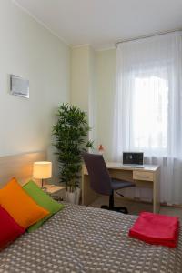 a room with a bed, chair, desk and a lamp at Apartamenty Media Park in Warsaw