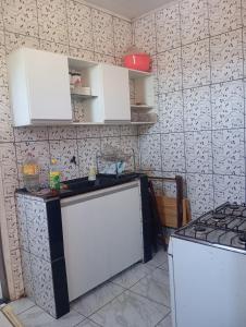 een keuken met witte kasten en een fornuis bij Casa próximo a praia do morro in Guarapari