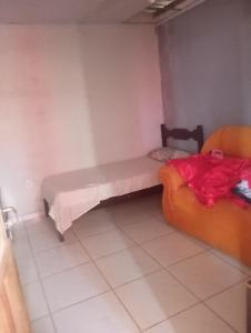 Cette chambre comprend un lit et un canapé. dans l'établissement Casa próximo a praia do morro, à Guarapari