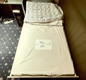 斯彻达尔Room Trondheim Airport的一张床上挂着一个牌子，上面写着“走”。