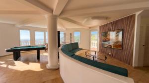 uma sala de estar com um sofá verde e um piano em Pearl of Paradise em Saint Martin