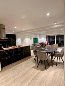 a kitchen and living room with a table and chairs at Nordic Panorama in Tromsø