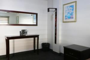 a room with a table and a mirror on a wall at HOTEL BUGAMBILIAS in Ensenada